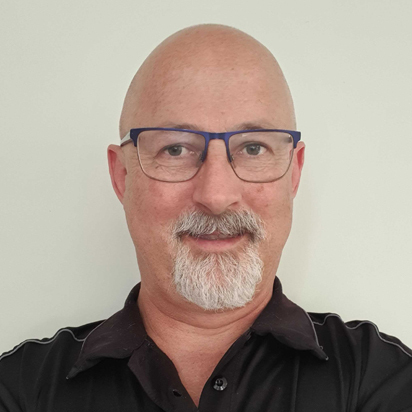 Portrait of Adrian, a team member at OptimySME, smiling in a business environment.