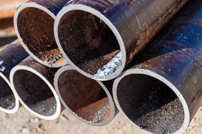 Close-up of industrial pipes, showing a smooth metal surface and connections in a factory setting